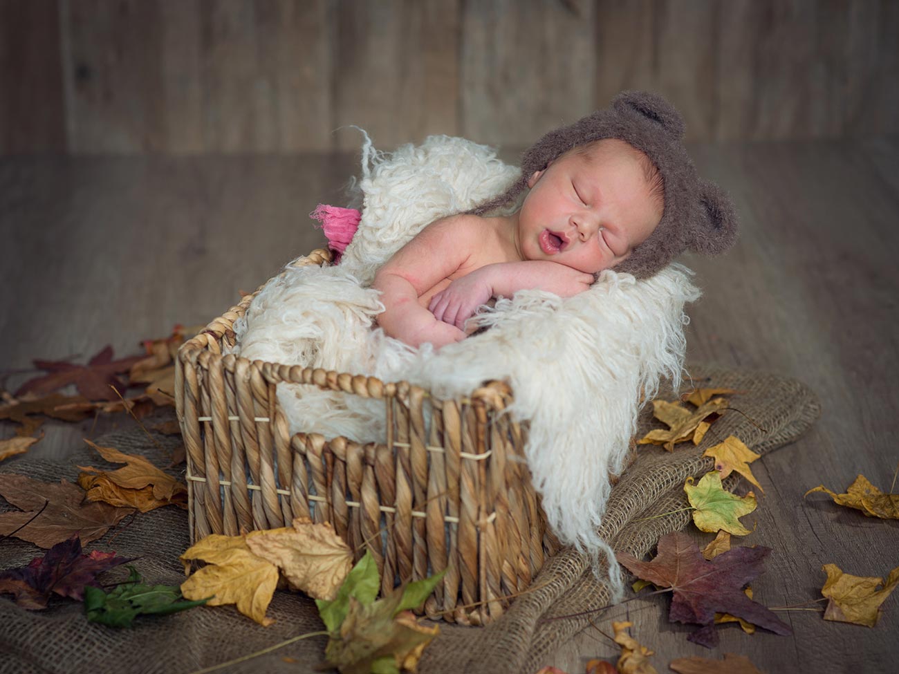 Fotografía de bebé recién nacido dormido en un caja