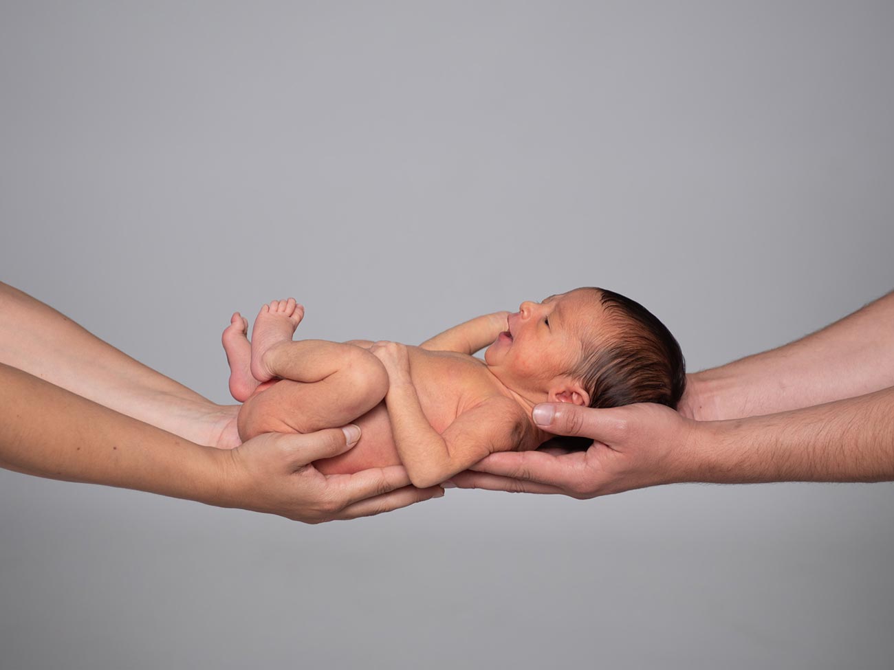 Bebé sobre las manos de sus padres