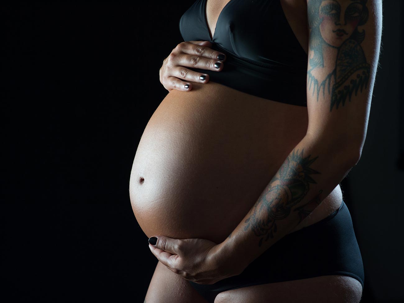 Fotografía barriga de embarazo sobre fondo negro